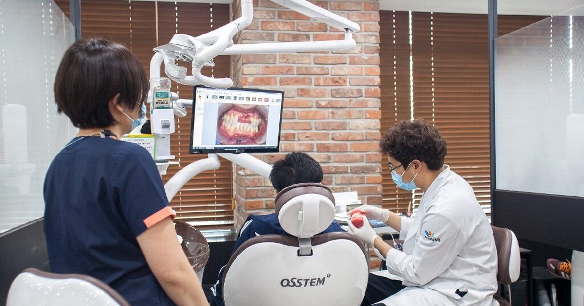부평 임플란트 — 부평우리치과 진료실에서 모니터 영상을 보며 진료하는 장면